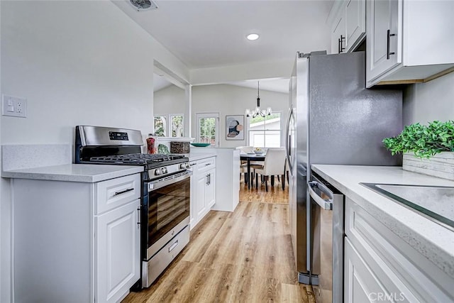 kitchen with a chandelier, light countertops, light wood-type flooring, and stainless steel appliances