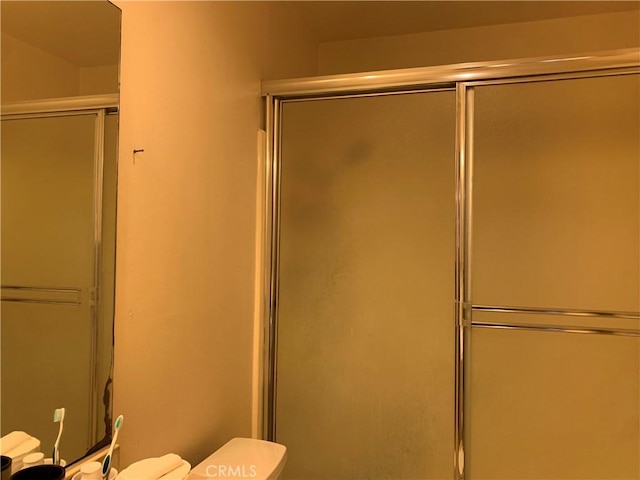 full bathroom featuring an enclosed shower and toilet