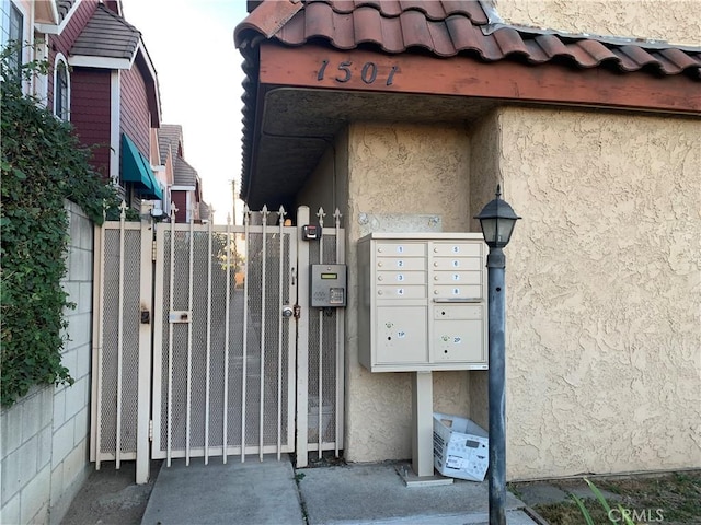 view of home's community featuring a gate, fence, and mail area