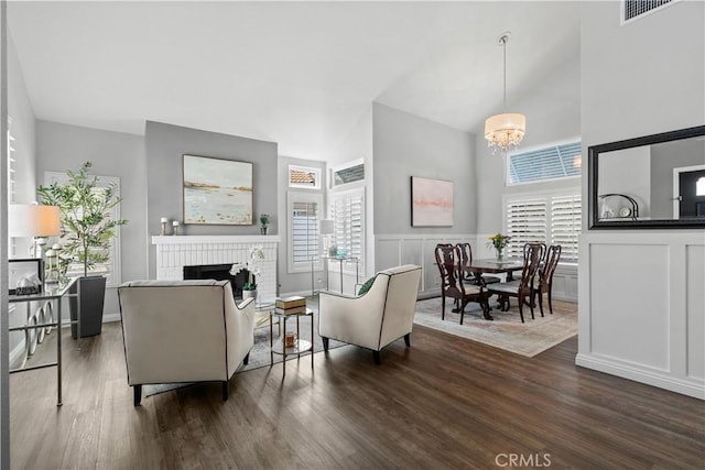 30151 Via Amante, Menifee, CA 92584 - living room featuring high vaulted ceiling, dark wood finished floors, a fireplace, a chandelier, and healthy amount of natural light
