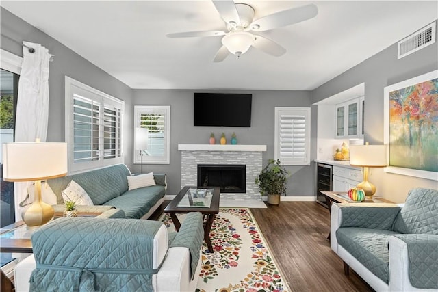 30151 Via Amante, Menifee, CA 92584 - living room with dark wood finished floors, beverage cooler, baseboards, a ceiling fan, and a fireplace