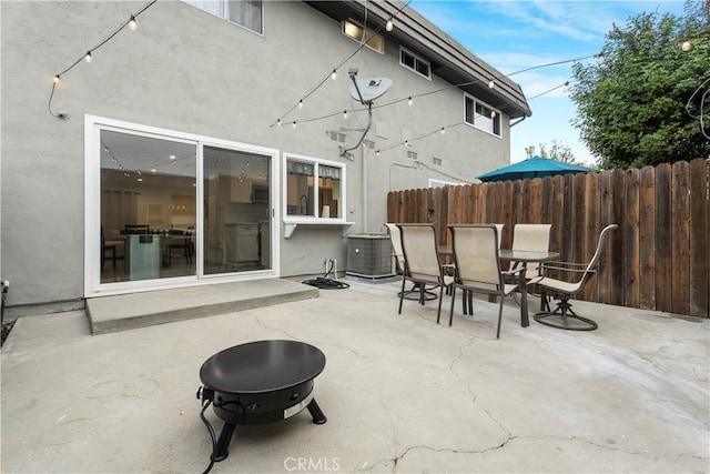 17730 Regency Cir, Bellflower, CA 90706 - view of patio featuring central AC unit, outdoor dining space, a fire pit, and fence
