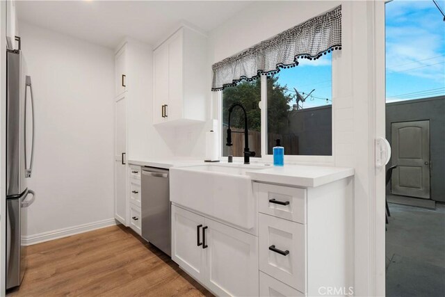 17730 Regency Cir, Bellflower, CA 90706 - kitchen with a sink, light wood finished floors, light countertops, white cabinets, and appliances with stainless steel finishes