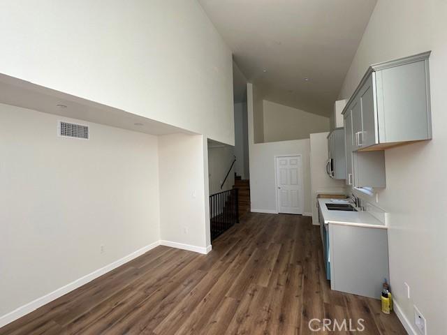 5507 S Manhattan Pl, Los Angeles, CA 90062 - kitchen featuring high vaulted ceiling, gray cabinets, visible vents, dark wood-style flooring, and light countertops