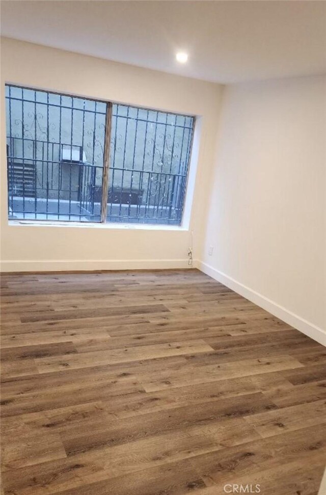 5507 S Manhattan Pl, Los Angeles, CA 90062 - unfurnished room featuring baseboards, recessed lighting, and wood finished floors