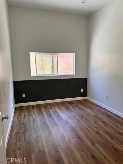 5507 S Manhattan Pl, Los Angeles, CA 90062 - spare room featuring baseboards, plenty of natural light, and wood finished floors