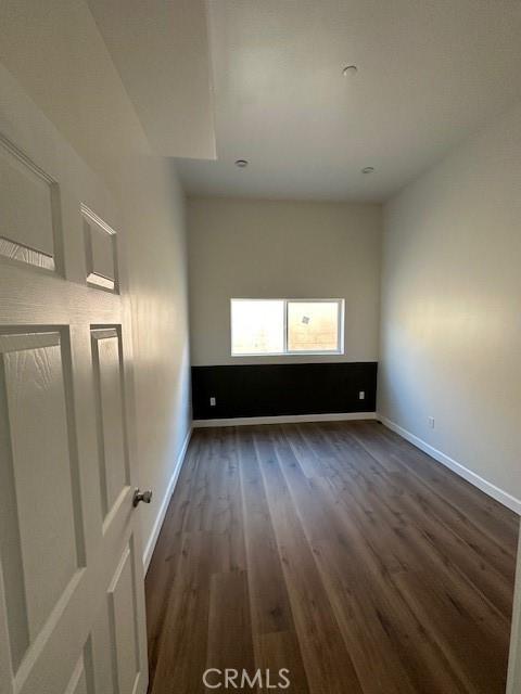 5507 S Manhattan Pl, Los Angeles, CA 90062 - spare room featuring baseboards and dark wood-type flooring
