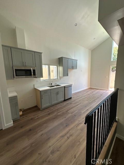 5507 S Manhattan Pl, Los Angeles, CA 90062 - kitchen with a sink, stainless steel appliances, gray cabinets, wood finished floors, and high vaulted ceiling
