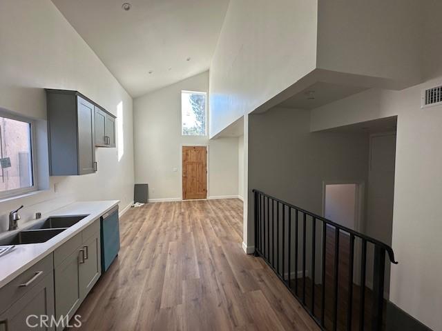 5507 S Manhattan Pl, Los Angeles, CA 90062 - interior space featuring a sink, high vaulted ceiling, light wood-type flooring, visible vents, and baseboards