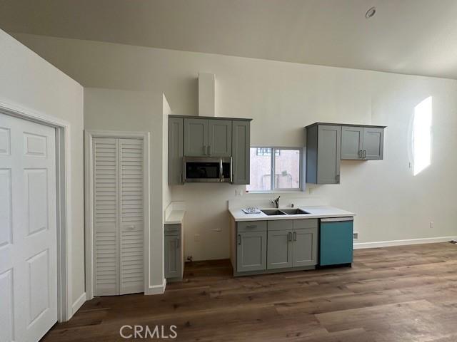5507 S Manhattan Pl, Los Angeles, CA 90062 - kitchen featuring stainless steel microwave, a sink, gray cabinets, wood finished floors, and dishwasher