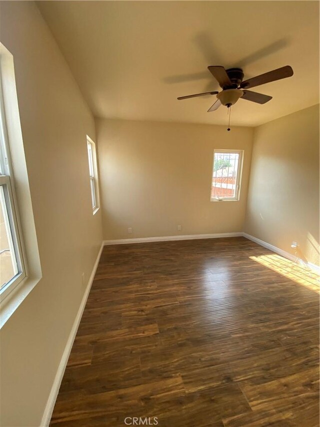 5507 S Manhattan Pl, Los Angeles, CA 90062 - spare room featuring dark wood-style flooring, baseboards, and a ceiling fan