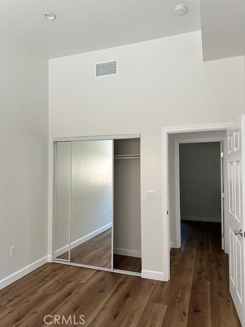 5507 S Manhattan Pl, Los Angeles, CA 90062 - unfurnished bedroom featuring a closet, baseboards, visible vents, and wood finished floors
