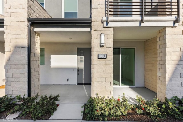 view of exterior entry featuring a balcony