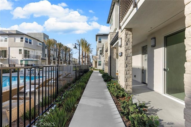 view of home's community featuring fence, a residential view, and a swimming pool