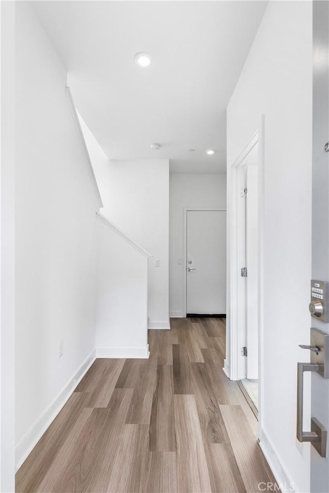 interior space featuring recessed lighting, baseboards, and wood finished floors