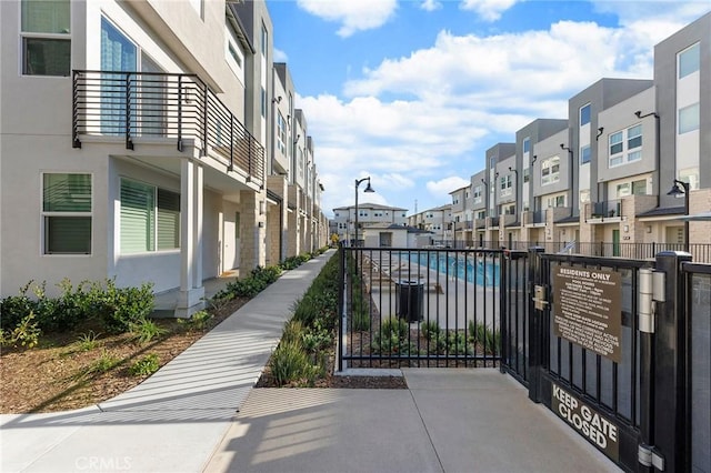 view of property's community featuring fence, a gate, and a residential view