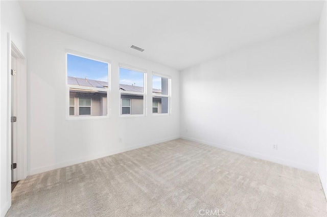 spare room featuring carpet, visible vents, and baseboards