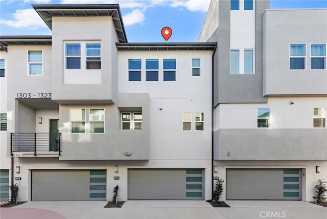 view of front of house featuring an attached garage, stucco siding, and driveway