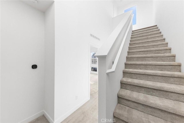stairway featuring carpet flooring, baseboards, and visible vents