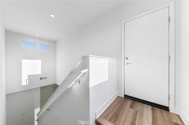 staircase featuring recessed lighting, baseboards, visible vents, and wood finished floors