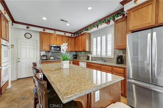31710 Waterfall Way, Murrieta, CA 92563 - kitchen with a breakfast bar area, visible vents, a sink, decorative backsplash, and stainless steel appliances