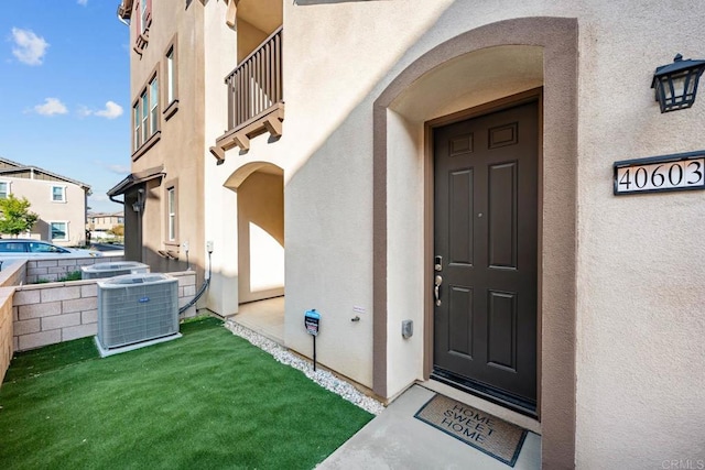 40603 Melrose Dr, Temecula, CA 92591 - view of exterior entry with stucco siding, central AC unit, and a balcony