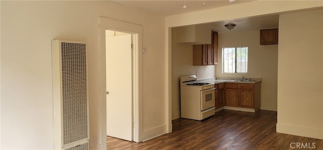 954 N Van Ness Ave, Los Angeles, CA 90038 - kitchen with a heating unit, brown cabinetry, dark wood-style flooring, light countertops, and white range with gas cooktop