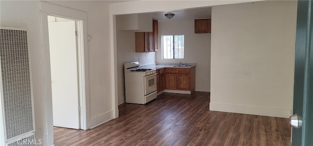 954 N Van Ness Ave, Los Angeles, CA 90038 - kitchen featuring a heating unit, white gas range, dark wood-style flooring, a sink, and brown cabinets