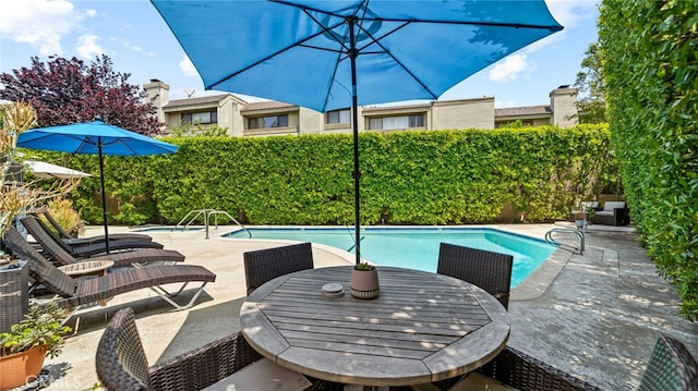 view of swimming pool with a fenced backyard and a patio