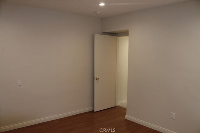 spare room with wood finished floors, baseboards, and recessed lighting