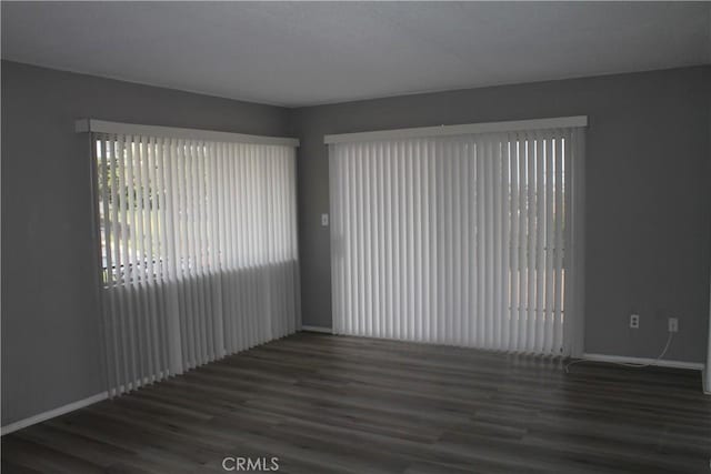 empty room with baseboards and wood finished floors