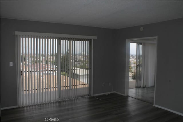 spare room featuring wood finished floors and baseboards