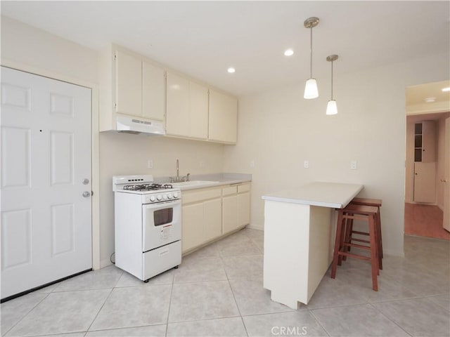 2302 S Gaffey St Unit 1, San Pedro, CA 90731 - kitchen featuring gas range gas stove, under cabinet range hood, cream cabinetry, light countertops, and a sink
