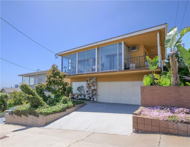 2302 S Gaffey St Unit 1, San Pedro, CA 90731 - view of front of property with concrete driveway, a wall mounted AC, an attached garage, and stone siding