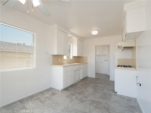 2302 S Gaffey St Unit 1, San Pedro, CA 90731 - kitchen with light countertops, gas stovetop, ceiling fan, a sink, and white cabinetry