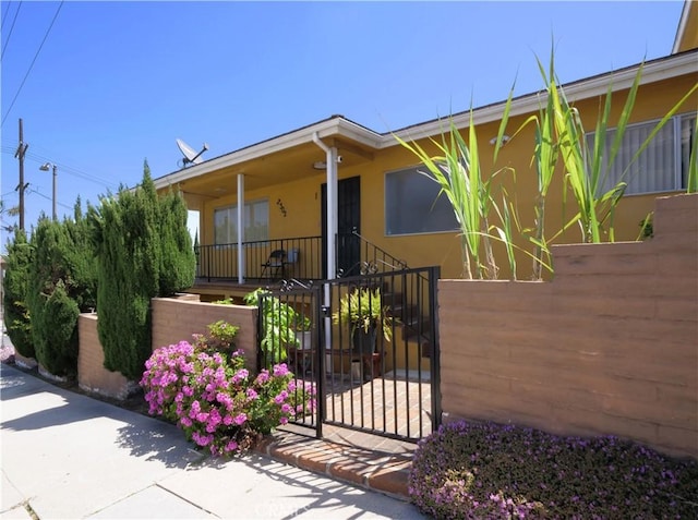 2302 S Gaffey St Unit 1, San Pedro, CA 90731 - view of front of house featuring a fenced front yard, stucco siding, a gate, and a porch