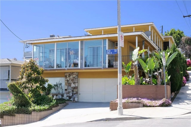 2302 S Gaffey St Unit 1, San Pedro, CA 90731 - view of front of house featuring an attached garage, concrete driveway, and stone siding
