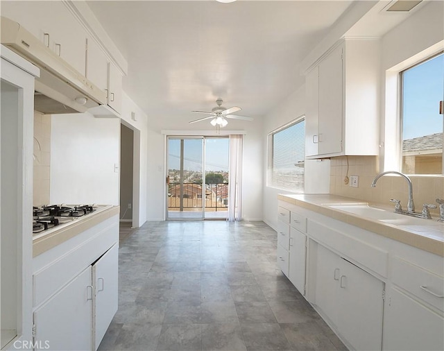 2302 S Gaffey St Unit 1, San Pedro, CA 90731 - kitchen featuring a sink, ceiling fan, white gas stovetop, white cabinetry, and decorative backsplash