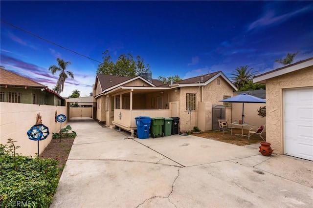 1449 W 45th St, Los Angeles, CA 90062 - back of house with a fenced backyard, a garage, a patio, and stucco siding