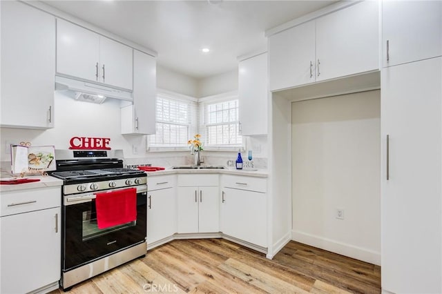 1449 W 45th St, Los Angeles, CA 90062 - kitchen with stainless steel gas stove, under cabinet range hood, a sink, light countertops, and recessed lighting