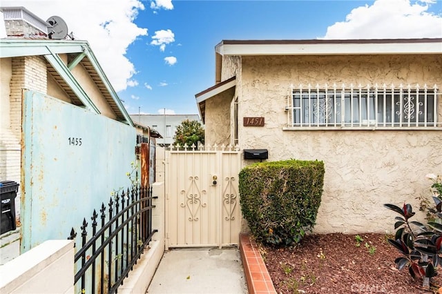 1449 W 45th St, Los Angeles, CA 90062 - view of home's exterior with stucco siding and a gate
