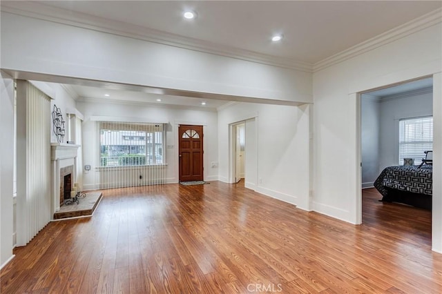 1449 W 45th St, Los Angeles, CA 90062 - entryway featuring wood finished floors, a fireplace with raised hearth, baseboards, crown molding, and recessed lighting