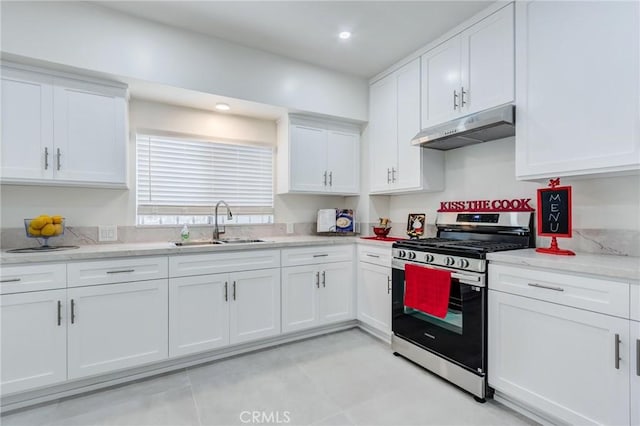 1449 W 45th St, Los Angeles, CA 90062 - kitchen featuring stainless steel gas range oven, under cabinet range hood, a sink, white cabinets, and light stone counters