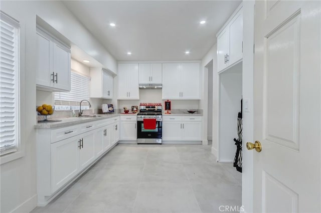 1449 W 45th St, Los Angeles, CA 90062 - kitchen featuring gas range, a sink, under cabinet range hood, light countertops, and white cabinetry