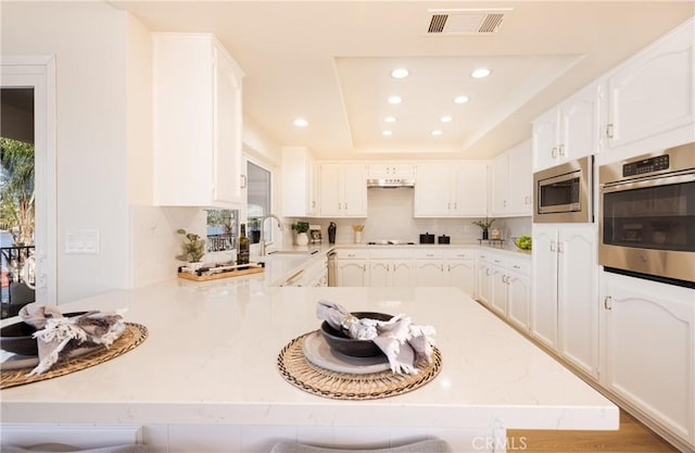 29284 Big Range Rd, Canyon Lake, CA 92587 - kitchen with appliances with stainless steel finishes, a peninsula, recessed lighting, a sink, and white cabinetry