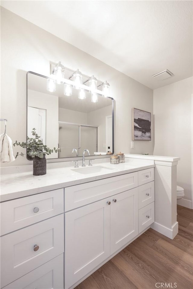 29284 Big Range Rd, Canyon Lake, CA 92587 - bathroom featuring wood finished floors, toilet, vanity, a shower stall, and baseboards