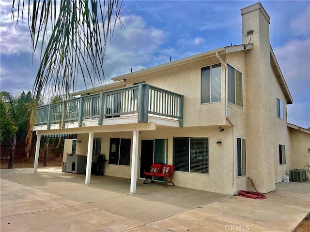 18725 Dallas Ave, Riverside, CA 92508 - back of house with a chimney, cooling unit, stucco siding, and a patio