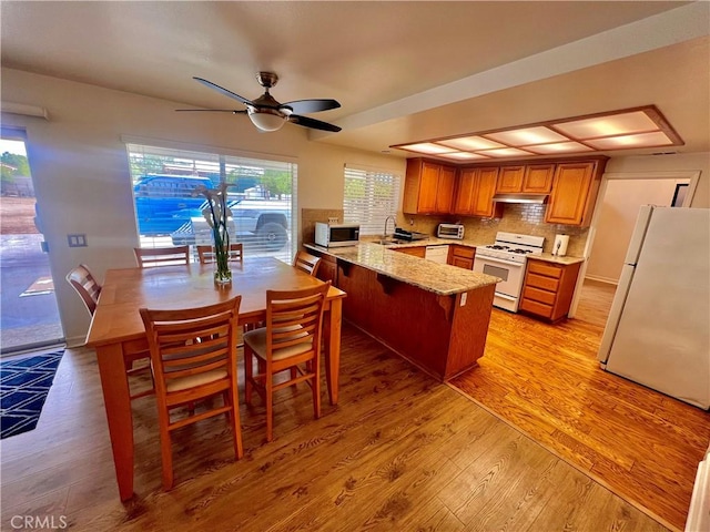 18725 Dallas Ave, Riverside, CA 92508 - kitchen with a peninsula, light wood finished floors, a ceiling fan, white appliances, and backsplash