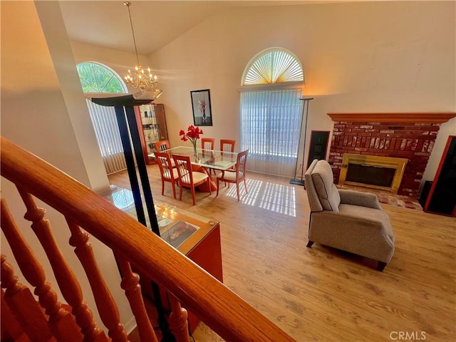 18725 Dallas Ave, Riverside, CA 92508 - living room with a brick fireplace, a chandelier, high vaulted ceiling, and wood finished floors