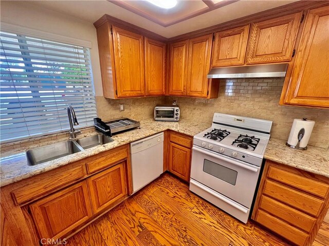 18725 Dallas Ave, Riverside, CA 92508 - kitchen with under cabinet range hood, brown cabinetry, white appliances, and a sink